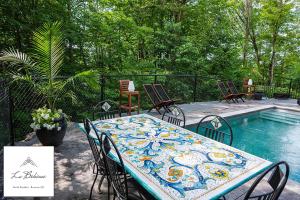 a table and chairs next to a swimming pool at La Bohème - Bed & Breakfast in Bromont