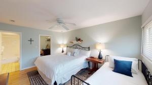Un dormitorio con una cama blanca y un sofá. en Beach Lover's Haven 2BR Villa at Heron Marsh, en Pawleys Island