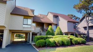 una casa con arbustos delante de ella en Beach Lover's Haven 2BR Villa at Heron Marsh, en Pawleys Island
