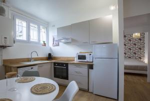 Il comprend une cuisine équipée d'un réfrigérateur blanc et d'une table. dans l'établissement Le Zandoli - Appart - Centre - Calme, à Blois