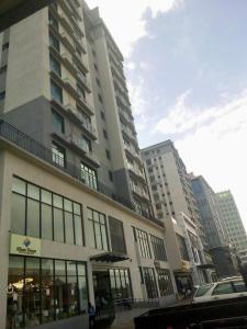 a tall building with windows in a city at Homely 2-Bedroom at Victoria Place in Dar es Salaam