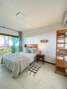 a bedroom with a bed and a window at Pousada Maré in Cumuruxatiba