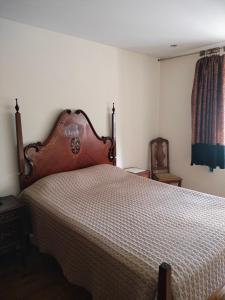una camera con un grande letto con testiera in legno di Rooms São Dinis a Porto