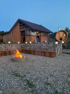 a fire pit in front of a log cabin at Apartament Pod Górką Gołdap in Gołdap