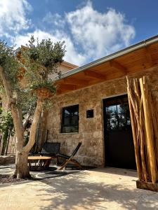 a house with a table and a tree in front of it at Hagafen Boutique Suites in Zikhron Ya‘aqov
