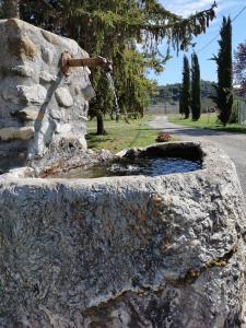 a stone wall with a water fountain at Appartement à la campagne 