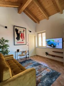 ein Wohnzimmer mit einem Sofa und einem TV in der Unterkunft S a p p h i r e H o M e - Rivarolo DesignApartment in Rivarolo Canavese