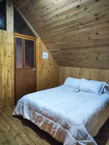 1 cama blanca grande en una habitación de madera en Maeponecoturismo, en Gámeza