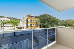 Apartment mit Balkon und Blick auf ein Gebäude in der Unterkunft Casa com Jacuzzi ideal para Férias de Famílias - 3 dorms 6 pessoas in Bombinhas