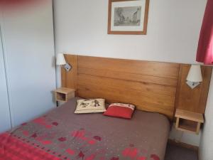 une petite chambre avec un lit avec une couverture rouge dans l'établissement Appart vue montagne Le Devoluy, à Saint-Étienne-en-Dévoluy