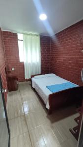 sypialnia z łóżkiem w ceglanej ścianie w obiekcie Bello Amanecer w mieście Las Palmas