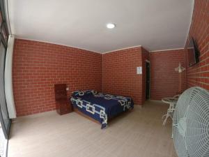 Cette chambre dispose d'un lit et d'un mur en briques. dans l'établissement Bello Amanecer, à Las Palmas