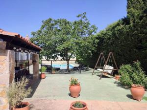un patio con piante in vaso e altalena di Cortijo El Algayubero a Puebla de Don Fadrique