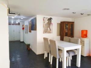 Un comedor con una mesa y sillas blancas. en HOSTAL con piscina en Palermo Soho!, en Buenos Aires 24 fotos más
