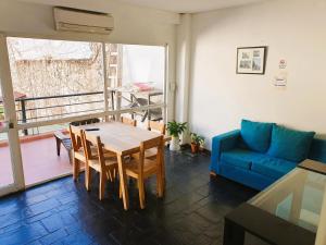 a living room with a table and a blue couch at Habitaciones en Casa con piscina en Palermo Soho! in Buenos Aires