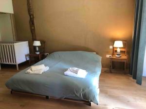 1 dormitorio con 1 cama con 2 toallas en Maison de charme avec vue, en Stoumont