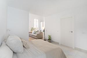 马德里Loft in the city的一间带床和沙发的白色卧室