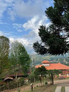 einen Blick auf ein Haus mit einem Berg im Hintergrund in der Unterkunft Casa de campo em Monte Verde , linda vista para montanhas in Monte Verde