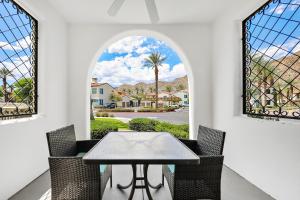 een eetkamer met een tafel en twee ramen bij Luxurious Villa with Majestic Mountain View, 12 Pools, Spas, Ground Floor in La Quinta