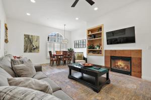 een woonkamer met een bank en een open haard bij Luxurious Villa with Majestic Mountain View, 12 Pools, Spas, Ground Floor in La Quinta