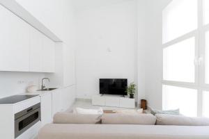 un soggiorno bianco con divano e TV di Loft in the city a Madrid