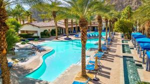 een afbeelding van een zwembad van het resort met palmbomen bij Luxurious Villa with Majestic Mountain View, 12 Pools, Spas, Ground Floor in La Quinta