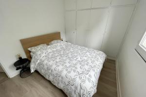 1 dormitorio con 1 cama con edredón blanco en Spacious cocoon at the gates of Paris, en Le Kremlin-Bicêtre