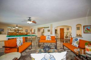 a living room with orange furniture and a pool table at ¡Nueva! Bamboo CASA ARTE in Cuernavaca