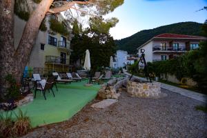 a yard with chairs and tables and a building at Apartments Cukovic in Herceg-Novi