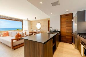 a kitchen and living room with a couch and a table at Stunning Oceanview Condo in San José del Cabo