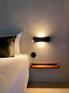 um quarto com uma cama e uma luz na parede em L'authentik petit hôtel Le Refuge de Mamie Yo 