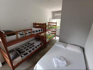 a room with two bunk beds and a bed at POUSADA PARAISO DO GAUCHO in Córrego das Panelas