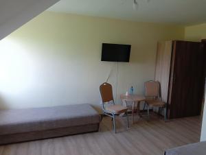 um quarto com uma cama, uma mesa e cadeiras em Hotel Romantyczny em Miedzyrzec Podlaski