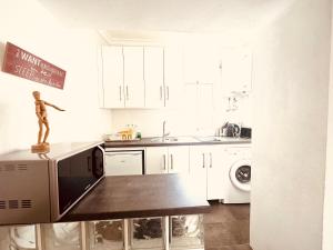 a kitchen with white cabinets and a statue on the counter at DUPLEX IN TARIFA'S OLD TOWN in Tarifa +20 photos