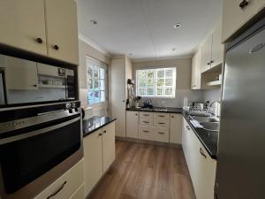 a kitchen with a sink and a stove top oven at Blu Belle Lagoon Cottage in Knysna