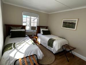 a bedroom with two beds and a window at Blu Belle Lagoon Cottage in Knysna