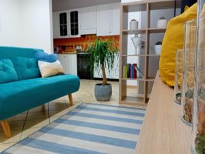 uma sala de estar com um sofá azul e uma cozinha em Casa vacanza Argo. Bovo marina/torre salsa em Montallegro