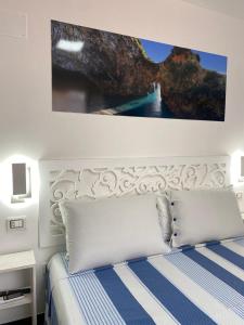 Un dormitorio con una cama con una pintura encima. en Al Vecchio Pioppo, en Praia a Mare