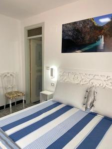 a bedroom with a bed with a blue and white stripes at Al Vecchio Pioppo in Praia a Mare