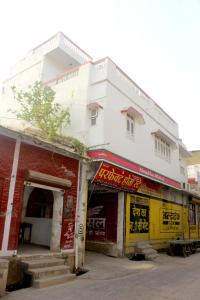 a white building next to a red brick building at Perfect Homestay Ujjain in Ujjain