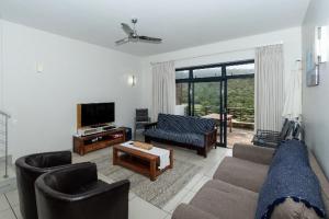 a living room with a couch and a tv at The Herolds Bay in Herolds Bay