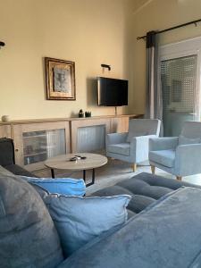 a living room with a couch and chairs and a table at Sissi - Villa Eleftheria in Sissi