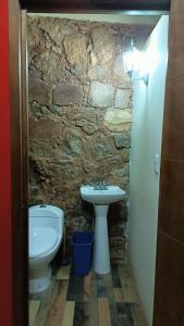 Baño de piedra con lavabo y aseo en Casa Flores en Zacatecas