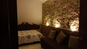 1 dormitorio con 1 cama y luces en la pared en Casa Flores en Zacatecas