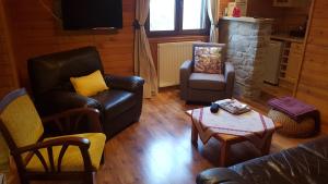 a living room with a couch and chairs and a table at "La Coustille" Chambres et Table d'Hôtes in Saint-Léger-les-Mélèzes