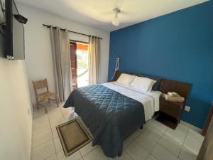 a bedroom with a bed with a blue wall at Pousada San Lorenzo in Joanópolis