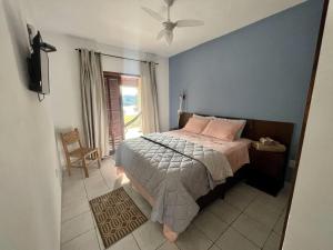 una camera da letto con un letto con cuscini rosa e una finestra di Pousada San Lorenzo a Joanópolis
