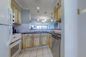 a kitchen with wooden cabinets and a sink at Mariners Cay 40 in Folly Beach