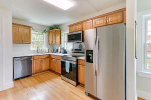 a kitchen with wooden cabinets and a stainless steel refrigerator at Chic Front Royal Retreat Near Shenandoah River! in Front Royal