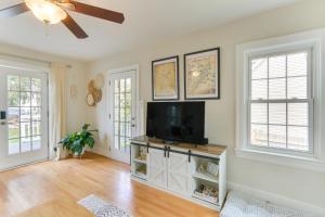 a living room with a flat screen tv and two windows at Chic Front Royal Retreat Near Shenandoah River! in Front Royal